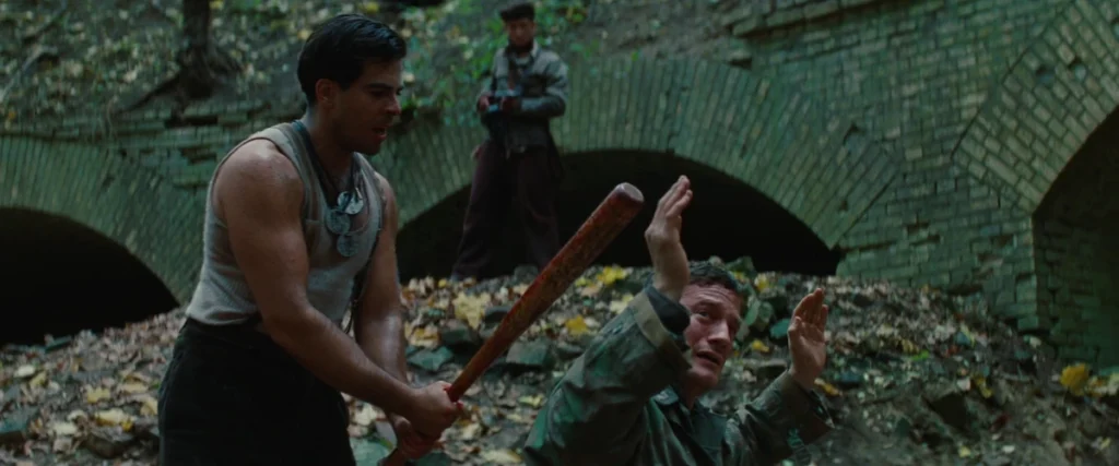 A Jew engaging in a cowardly homocide by bashing in a prisoner's skull with a baseball bat. He is enabled by multiple gunmen ready to fire.
